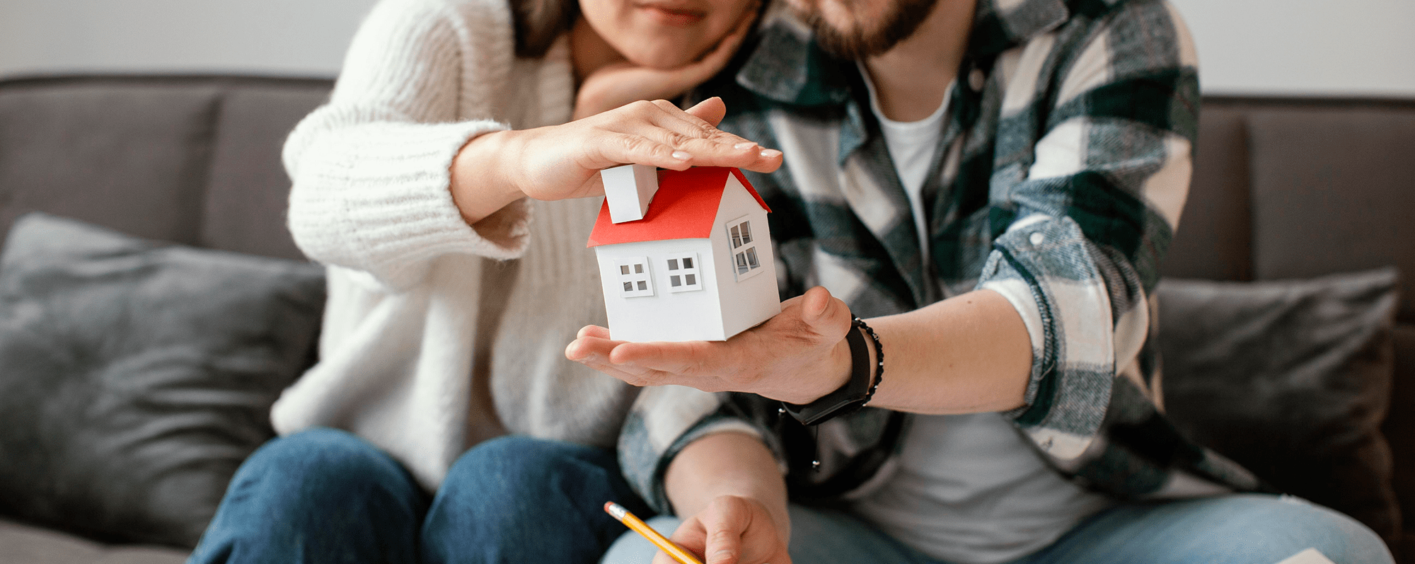 couple-holding-small-house-medium-shot 1-min