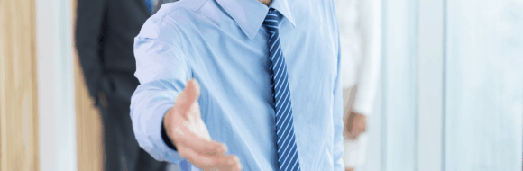 serious-businessman-extending-hand-handshake 1-min